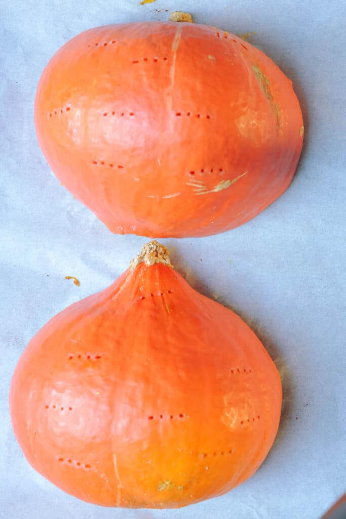 Hokkaido pumpkin halves pierced on a baking tray