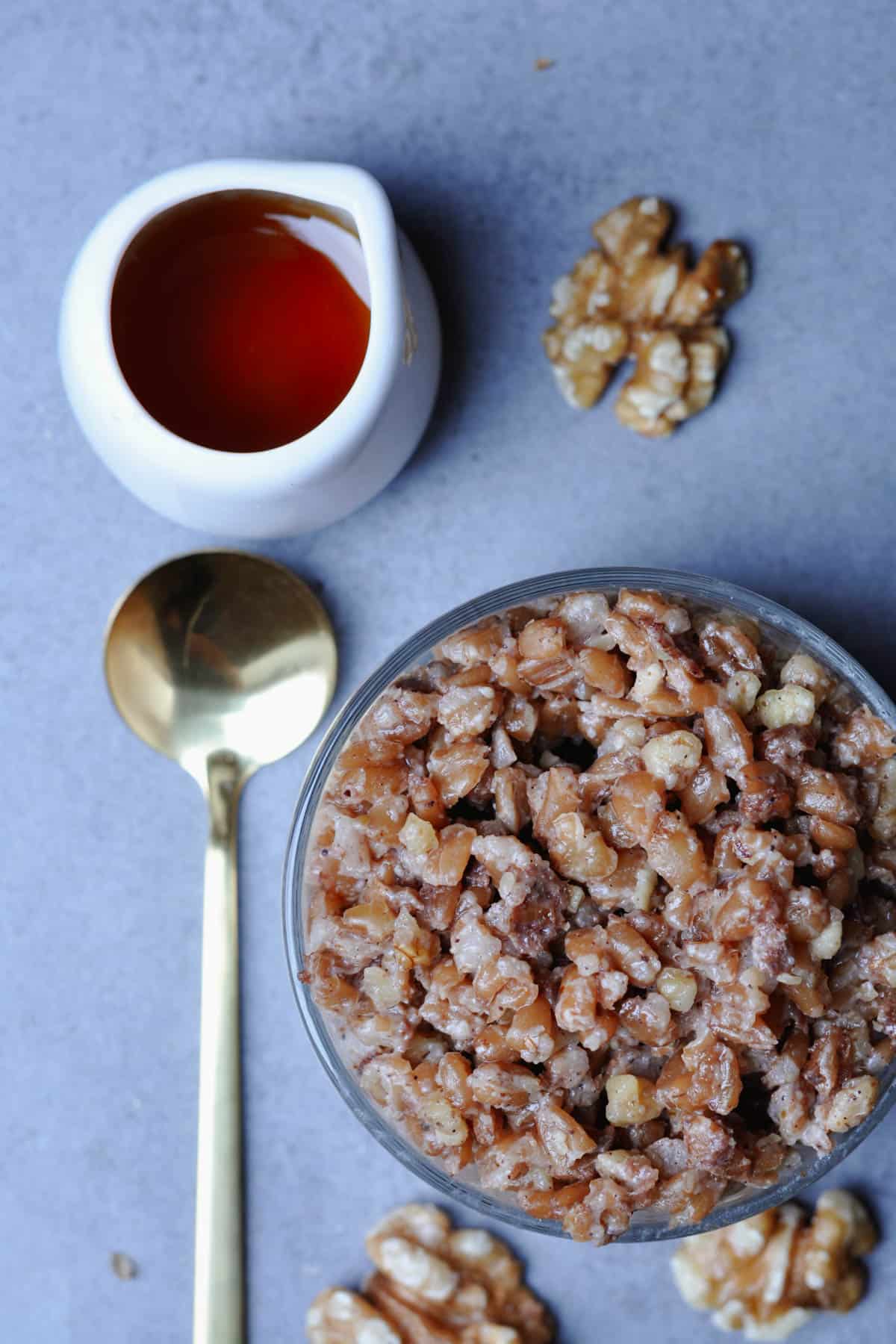 Glass with farro dessert golden spoon and maple syrup