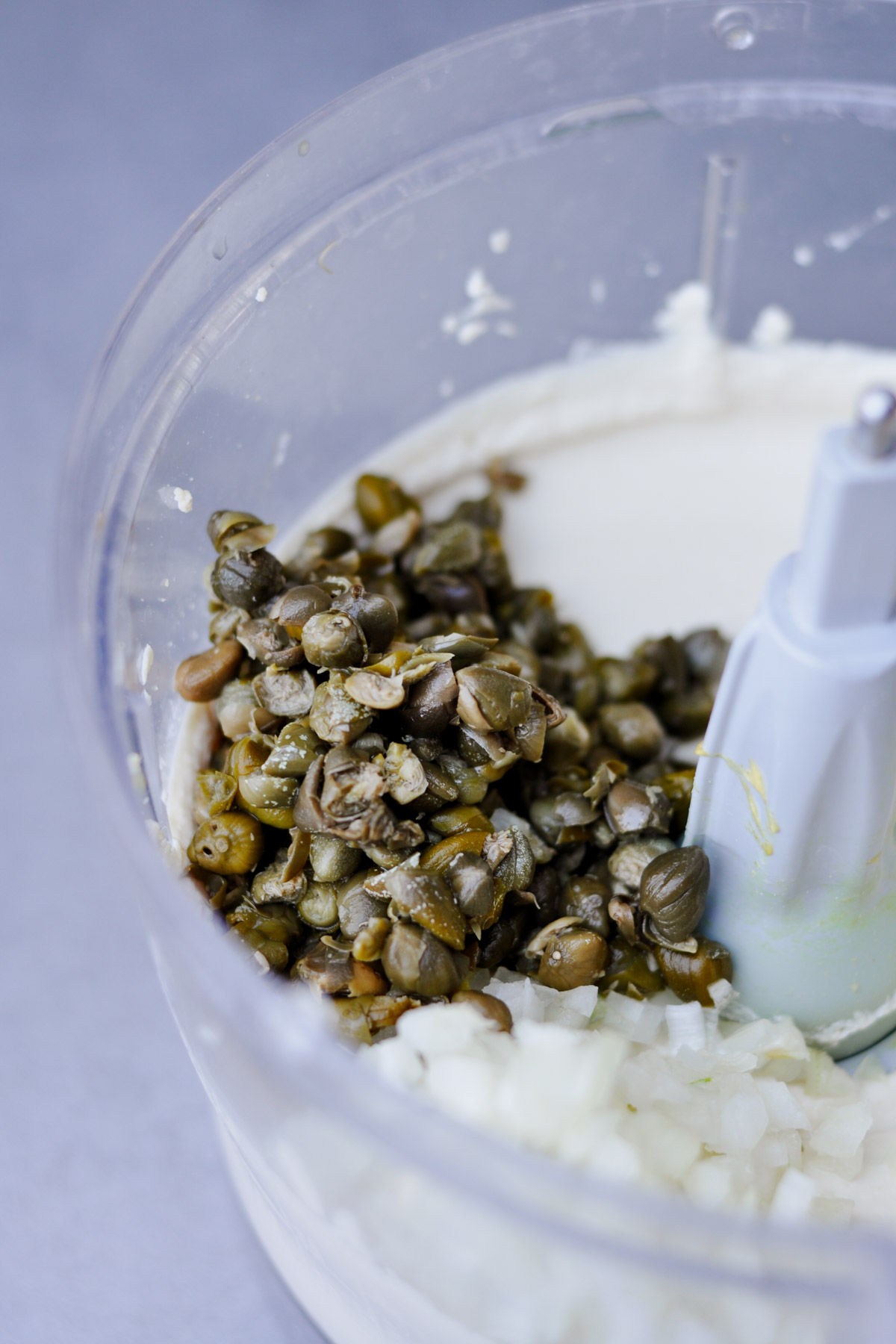 creamy tofu in a food processor with capers and chopped onions