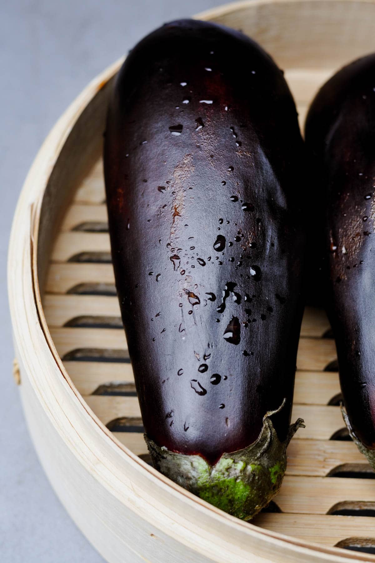 Freshly washed aubergine (eggplant) in a bamboo steamer