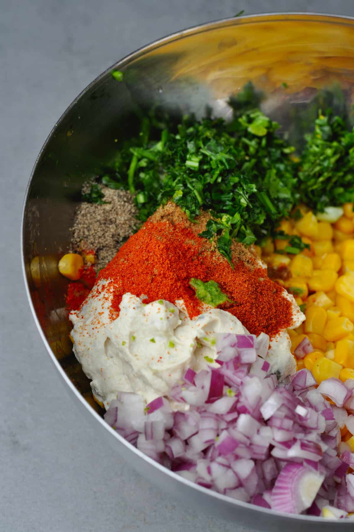 ingredients for a corn elote salad in a bowl