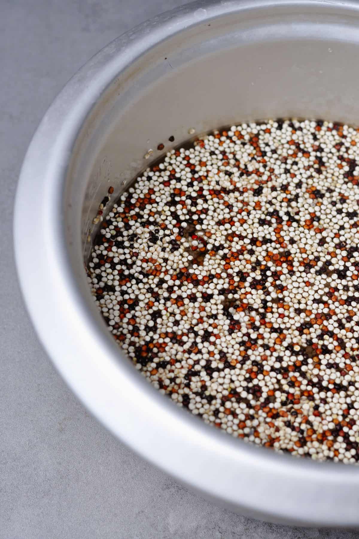 Tri-color quinoa and water in a rice cooker