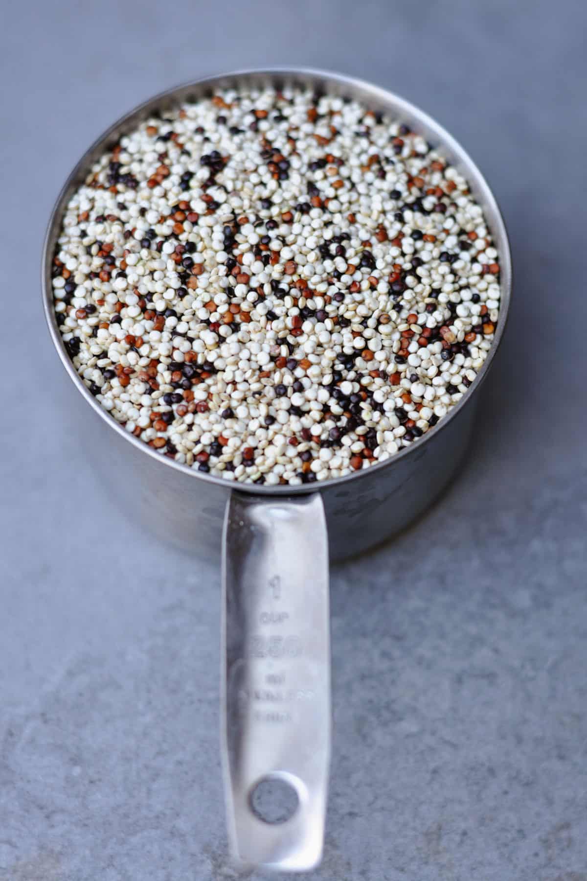 uncooked tri color quinoa in a cup