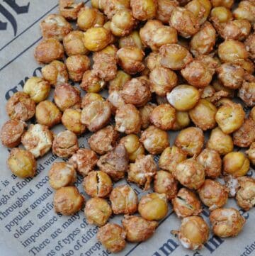 roasted chickpeas with spices mix of nutritional yeast, chili powder and salt on a piece of newspaper