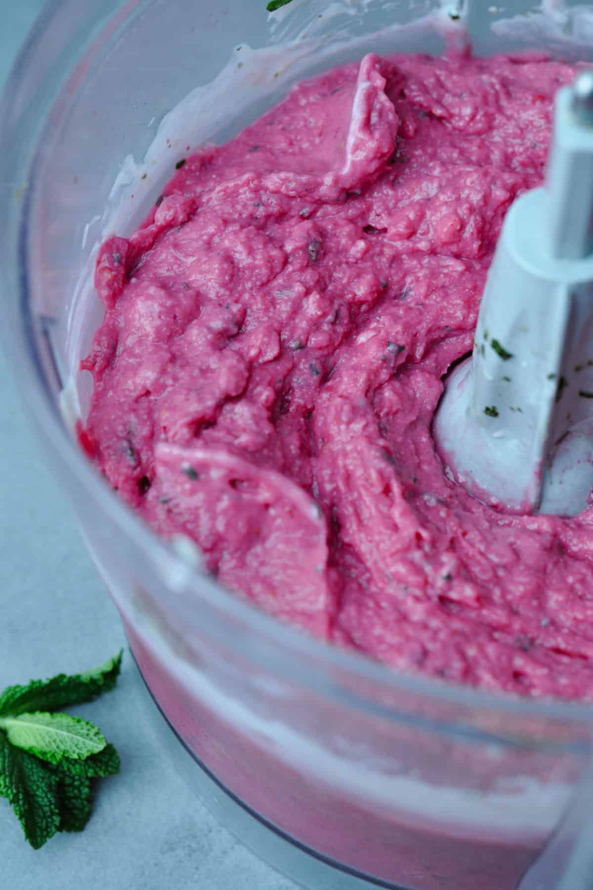 Raspberries, peaches and mint frozen yogurt in a food processor