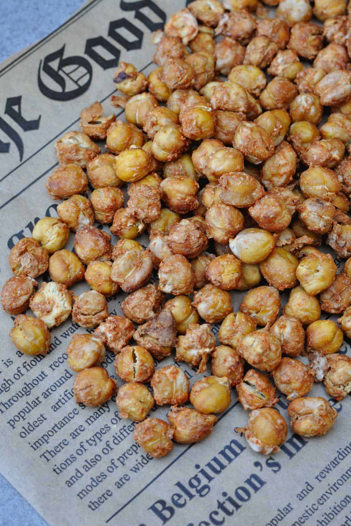 Roasted chickpeas with spices mix of nutritional yeast, chili powder and salt on a piece of newspaper