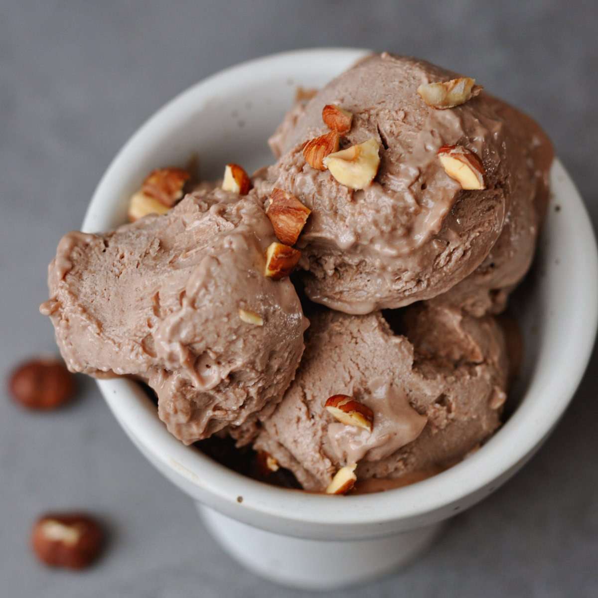 Bowl of Vegan Nocciola Gelato topped with chopped hazelnuts. This creamy, dairy-fre