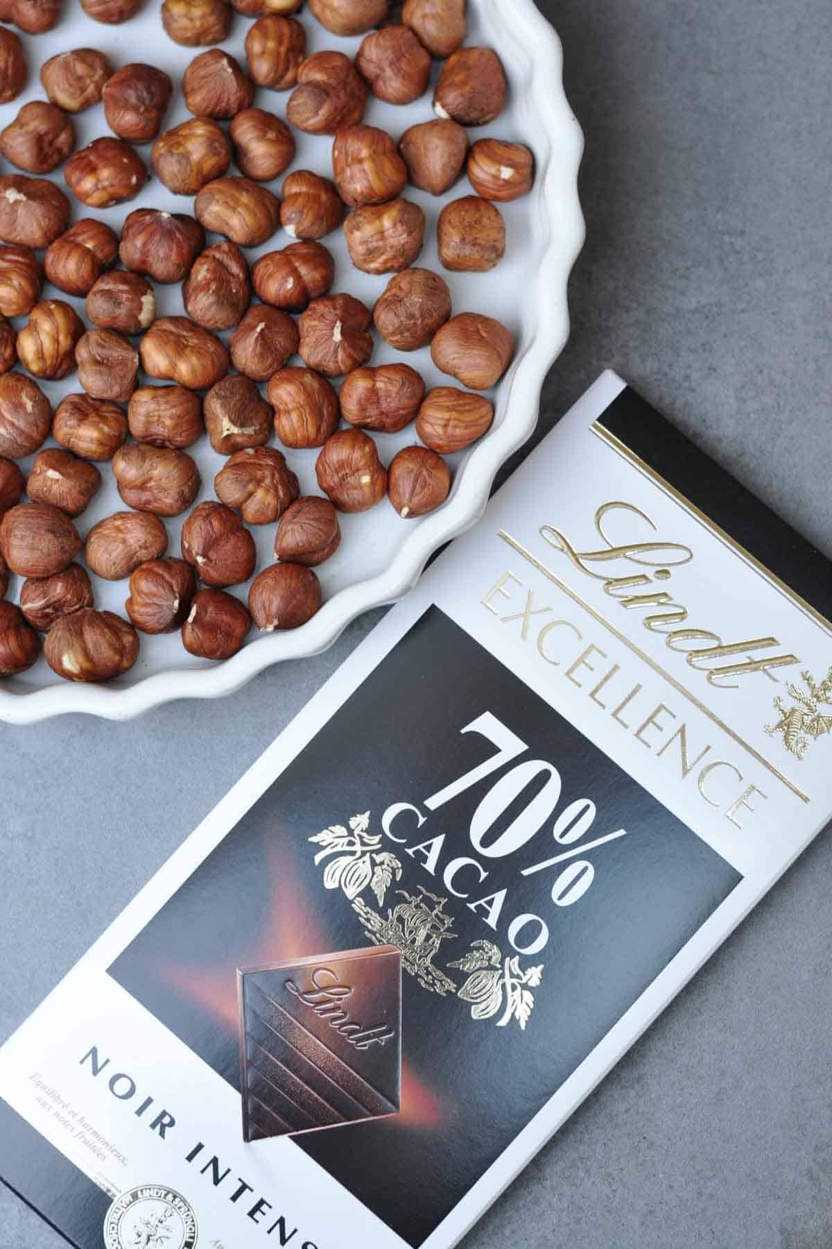 hazelnuts and dark chocolate on a table.