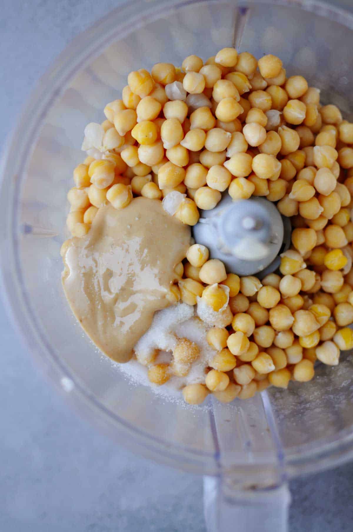 ingredients for simple roasted pine nut butter hummus in a food processor. 