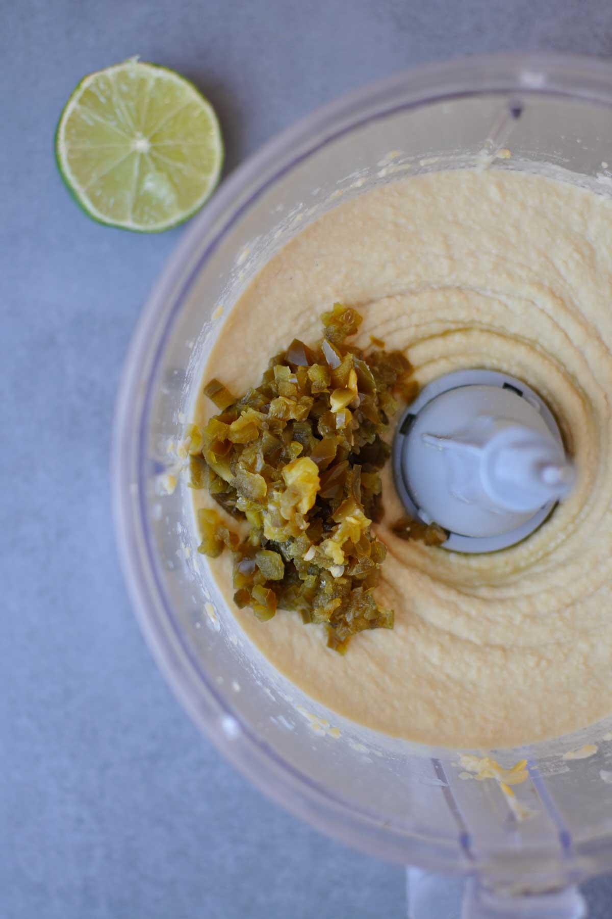 spicy jalapeno hummus with minced pickled jalapeno in a food processor. 