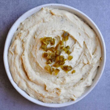 spicy jalapeno hummus without tahini on a white plate.